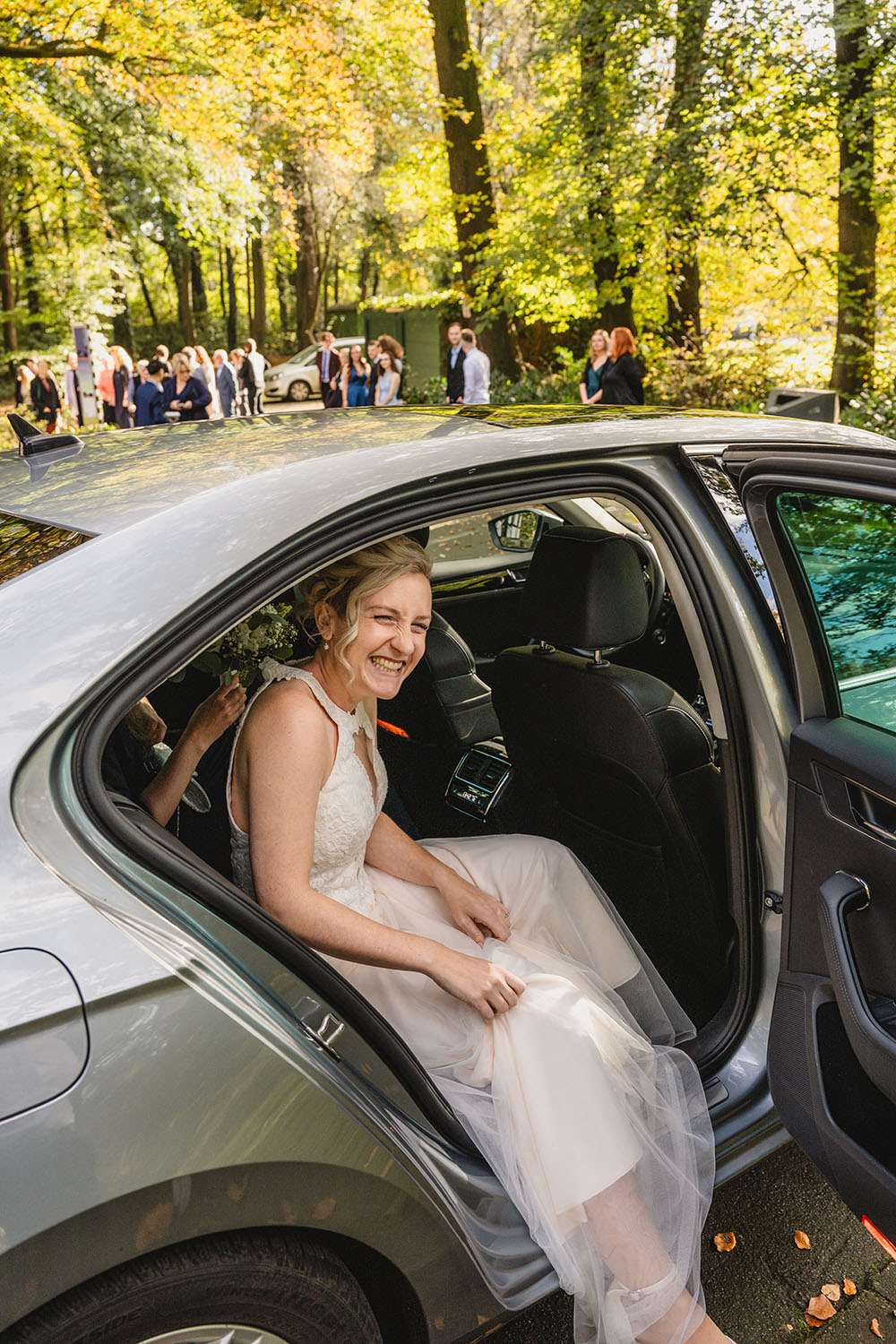 Braut steigt aus dem Auto aus