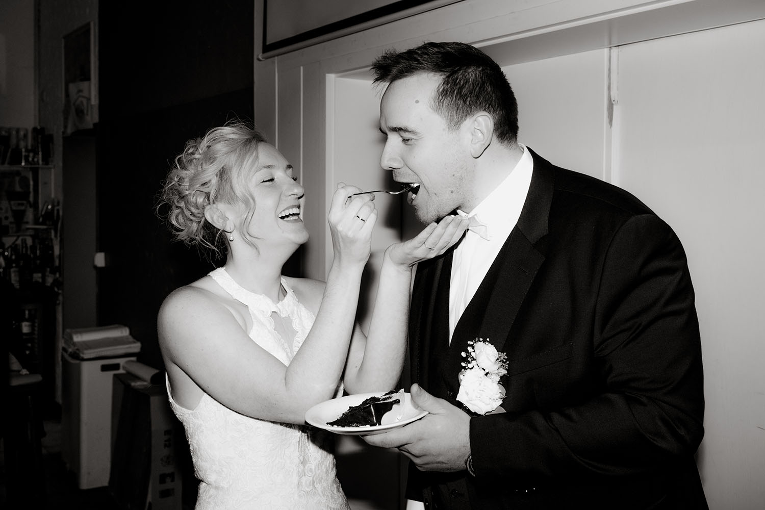 Glückliches Brautpaar isst Hochzeitstorte