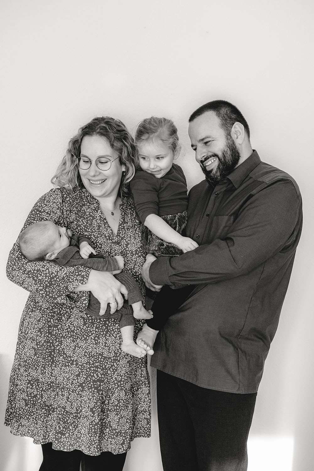 Glückliche Familie schaut zum Baby fotografiert in Schwarz Weiß