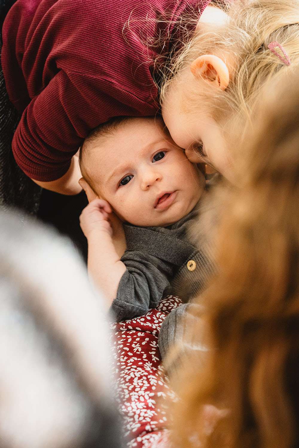Schwester gibt dem neugeborenen Baby einen Kuss