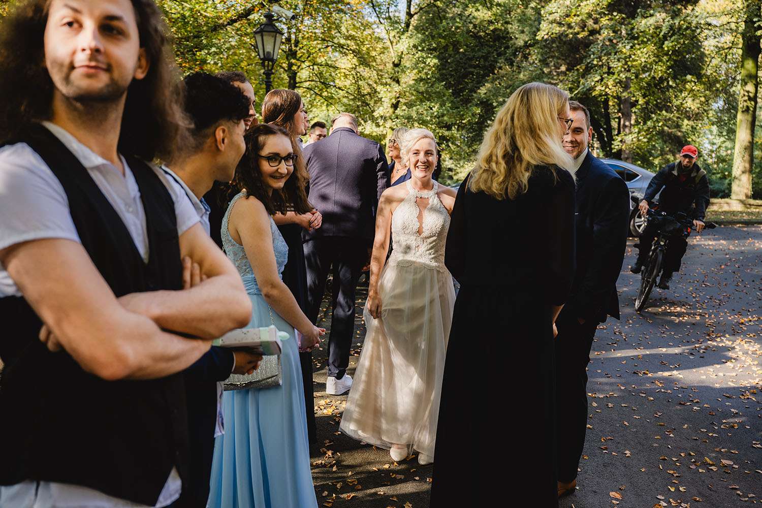 Lachende Personen auf einer Hochzeit unter Bäumen