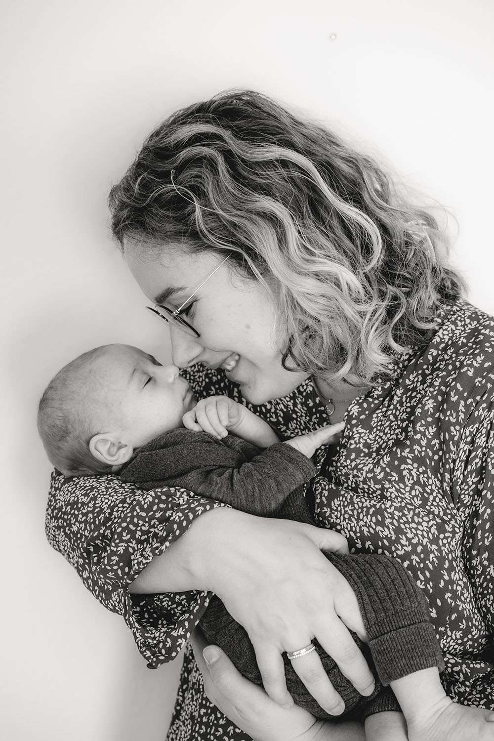Mama hält Baby auf dem Arm fotografiert in Schwarz Weiß