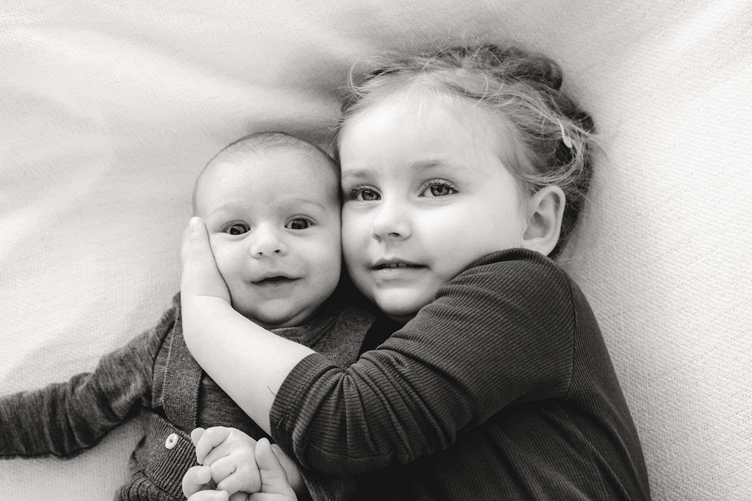 Bruder und Schwester liegend Kopf an Kopf