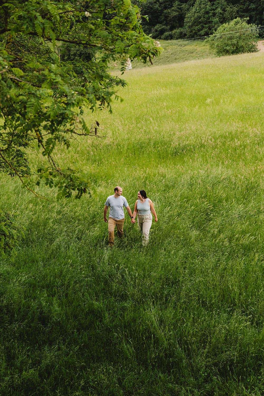 Mann und frau laufen Hand in Hand über eine Wiese