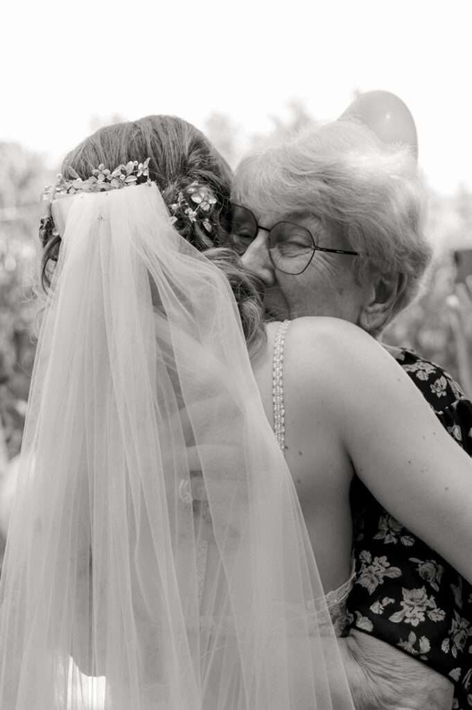 Großmutter umarmt die Braut fotografiert in schwarz-weiß