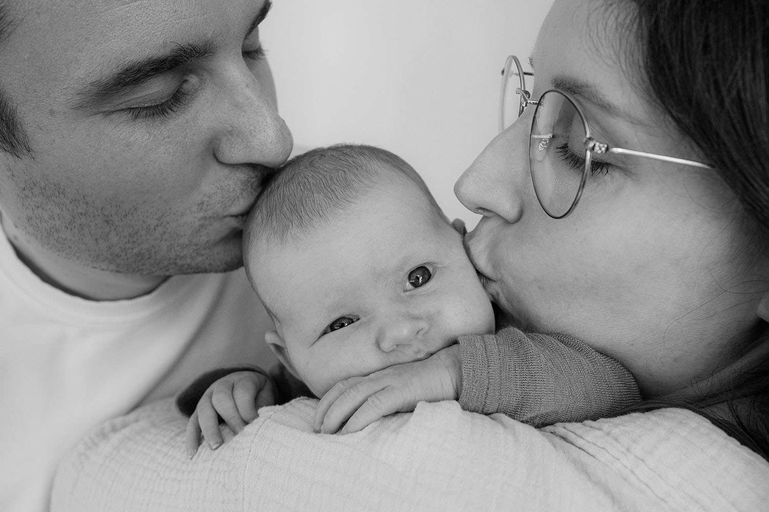 Eltern geben Baby einen Kuss auf die Wangen