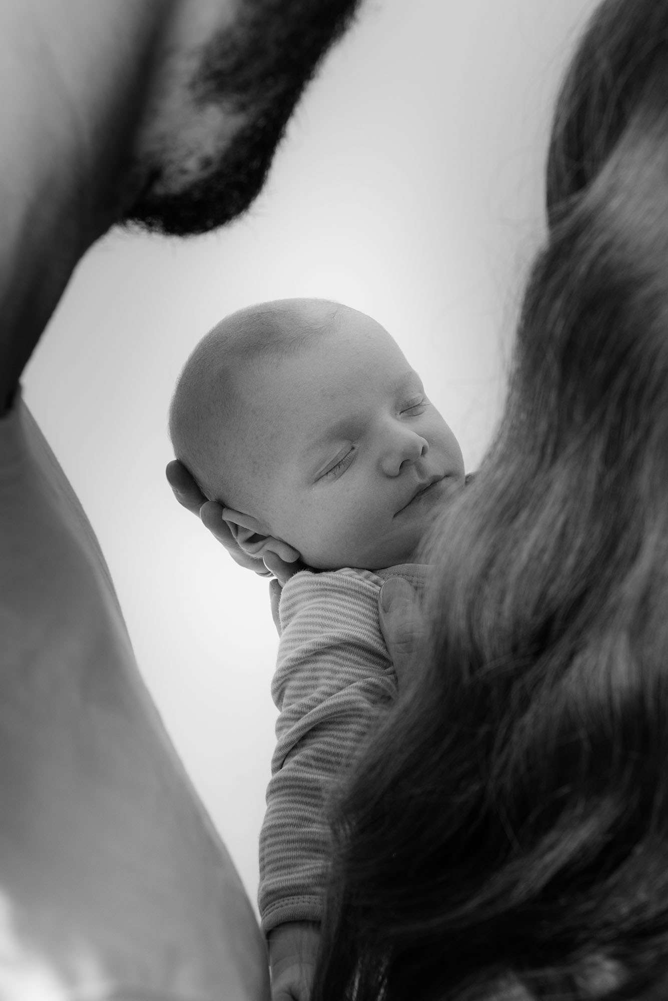 Eltern halten ihr Baby bei einem Newborn-Shooting im Studio