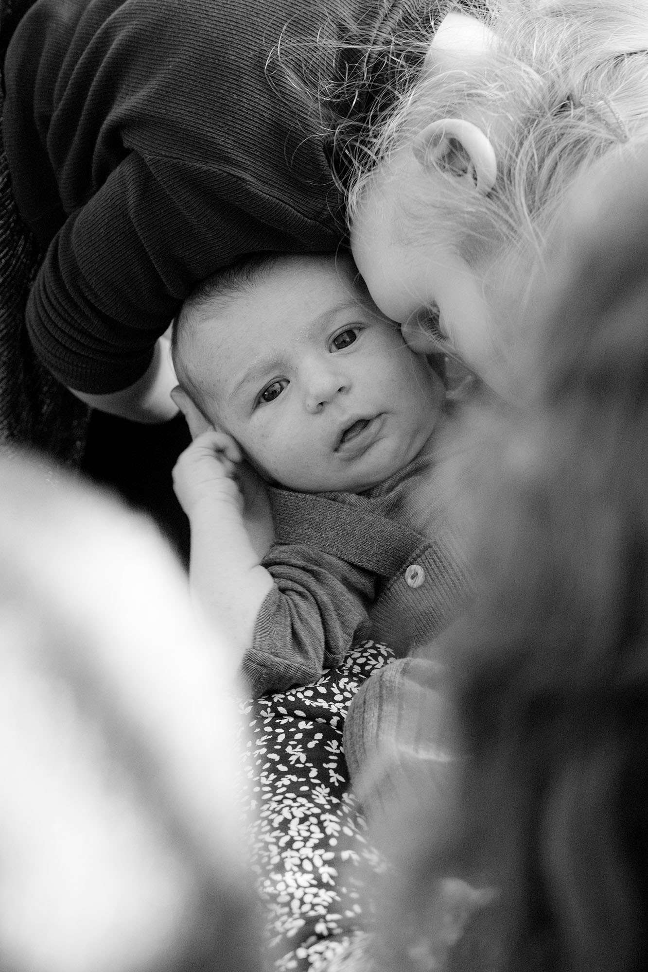 Schwester gibt ihrem neugeborenen Bruder einen Kuss