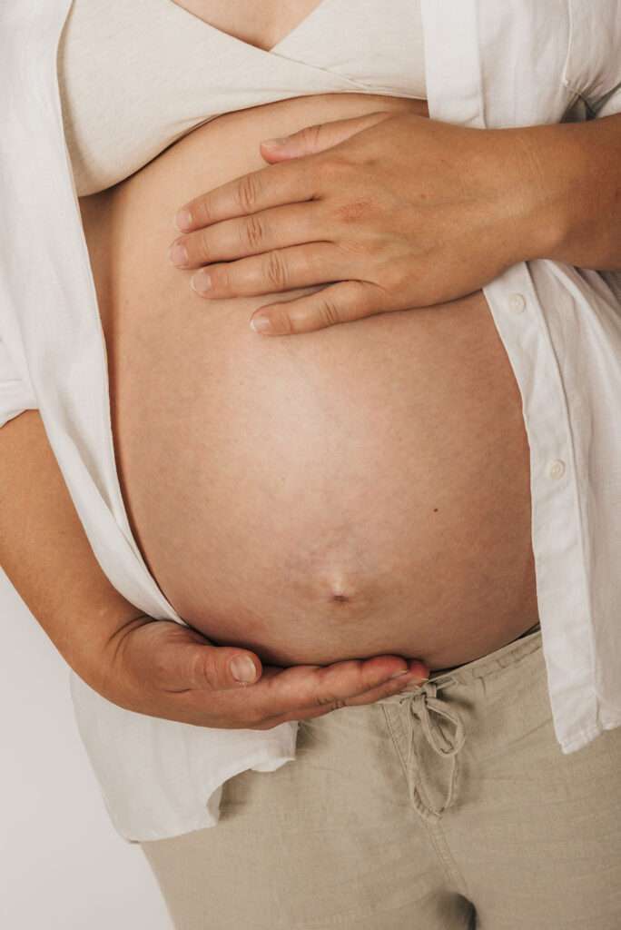 nackter babybauch mit Händen