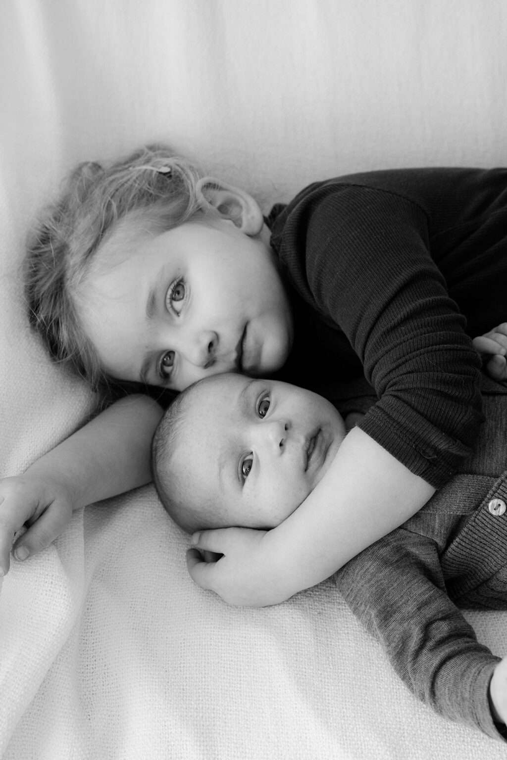 Geschwister liegen auf der Couch