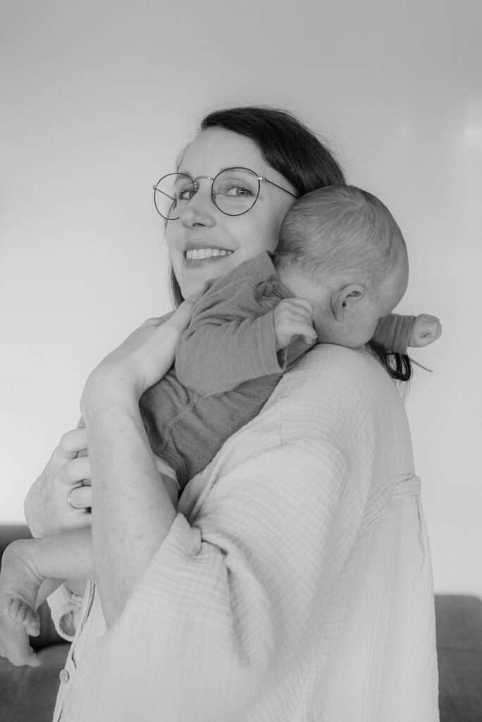 Mutter habt Baby und schaut in die kamera fotografiert in schwarz-weiß