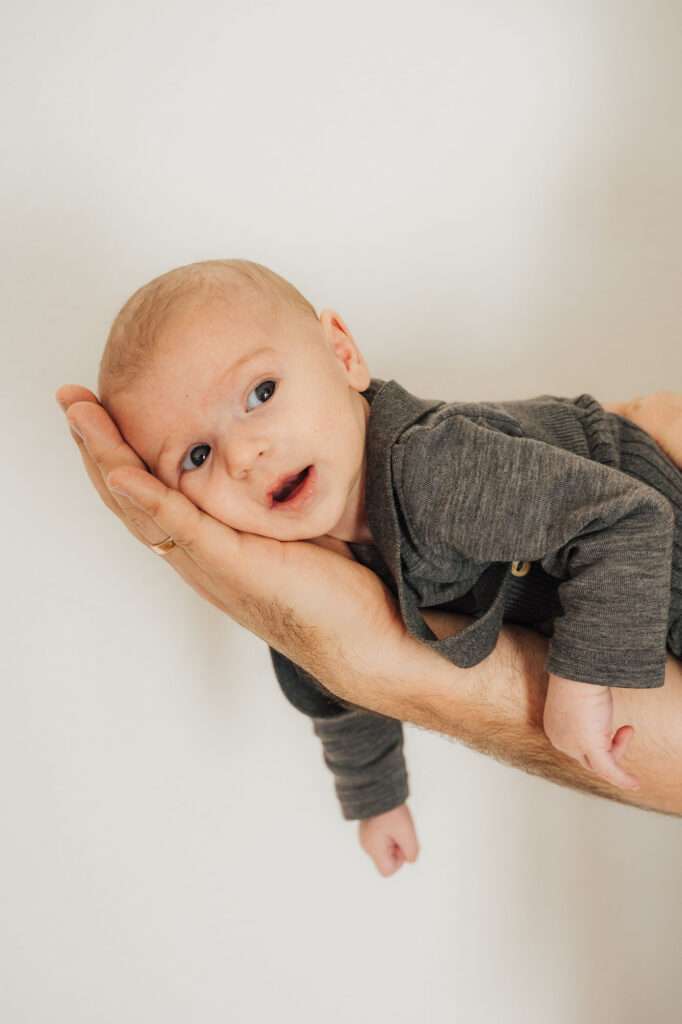 Baby liegt auf der Hand des Vaters