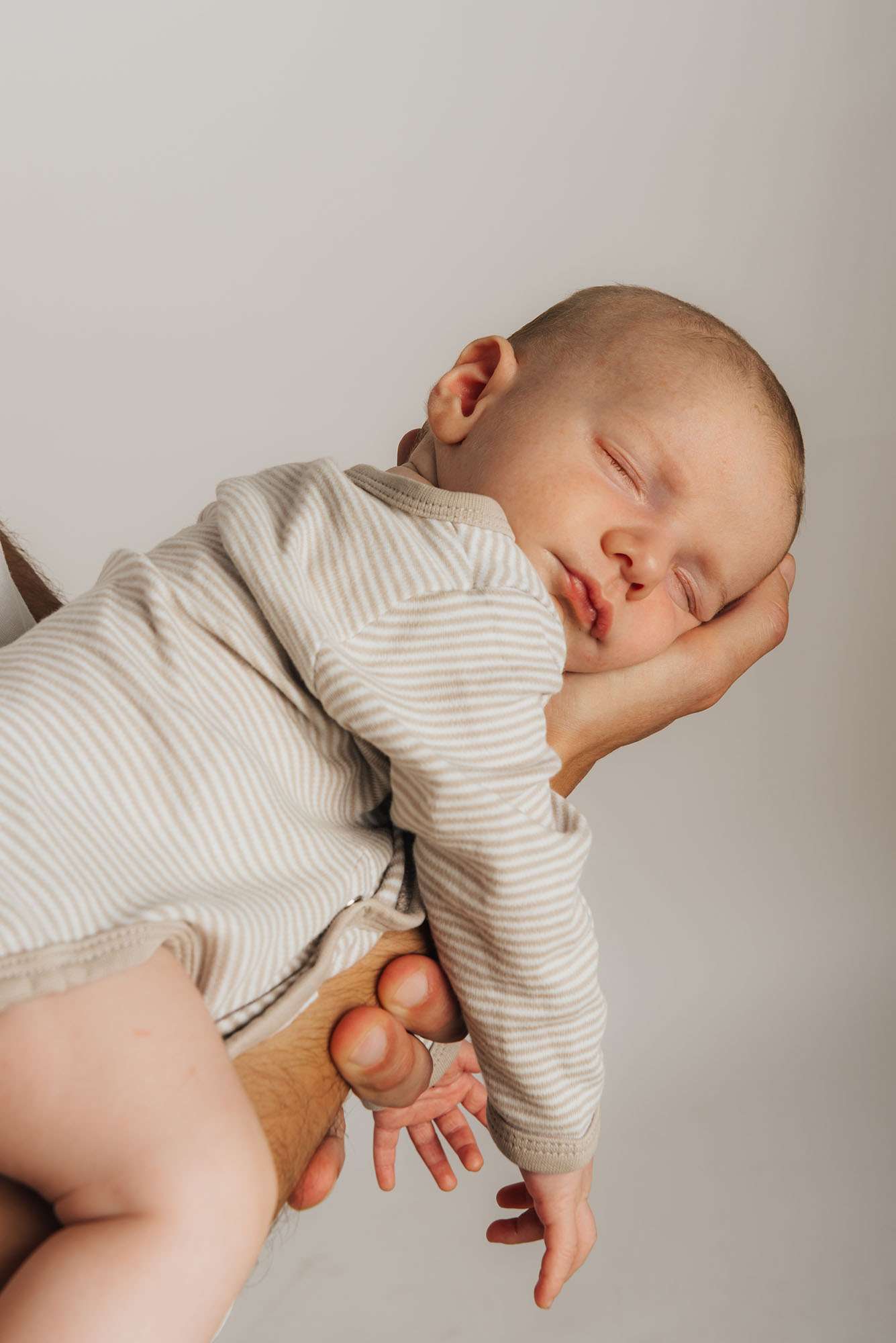Schlafendes Baby liegt auf der Hand des Vaters