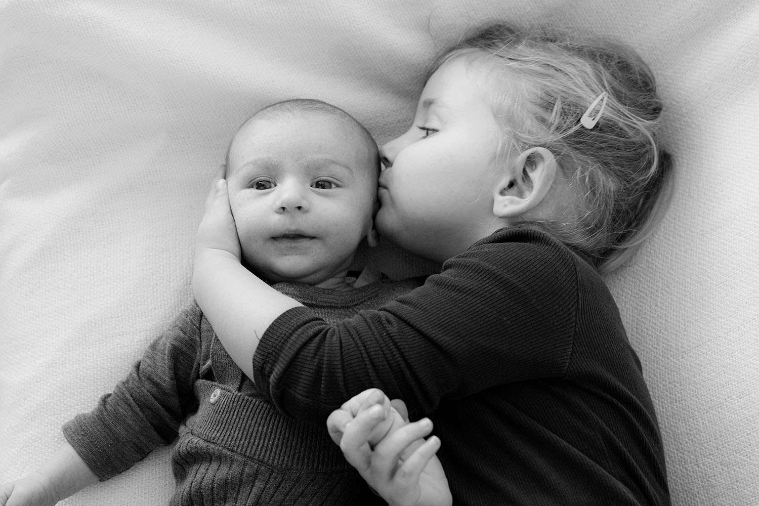 Schwester gibt Bruder einen Kuss